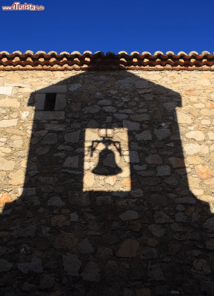 Immagine L'ombra del campanile e della campana di San Martino sul muro in pietra di un edificio, Trujillo, con la luce del tardo pomeriggio.
