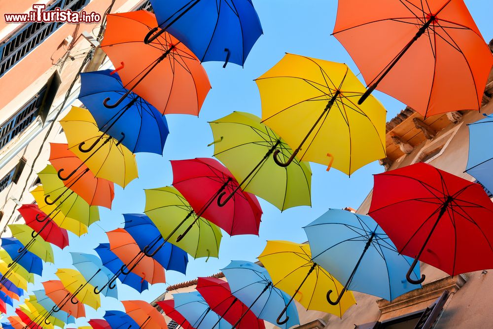 Immagine Ombrelli colorati decorano una strada dello shopping nella città vecchia di Novigrad, Croazia.