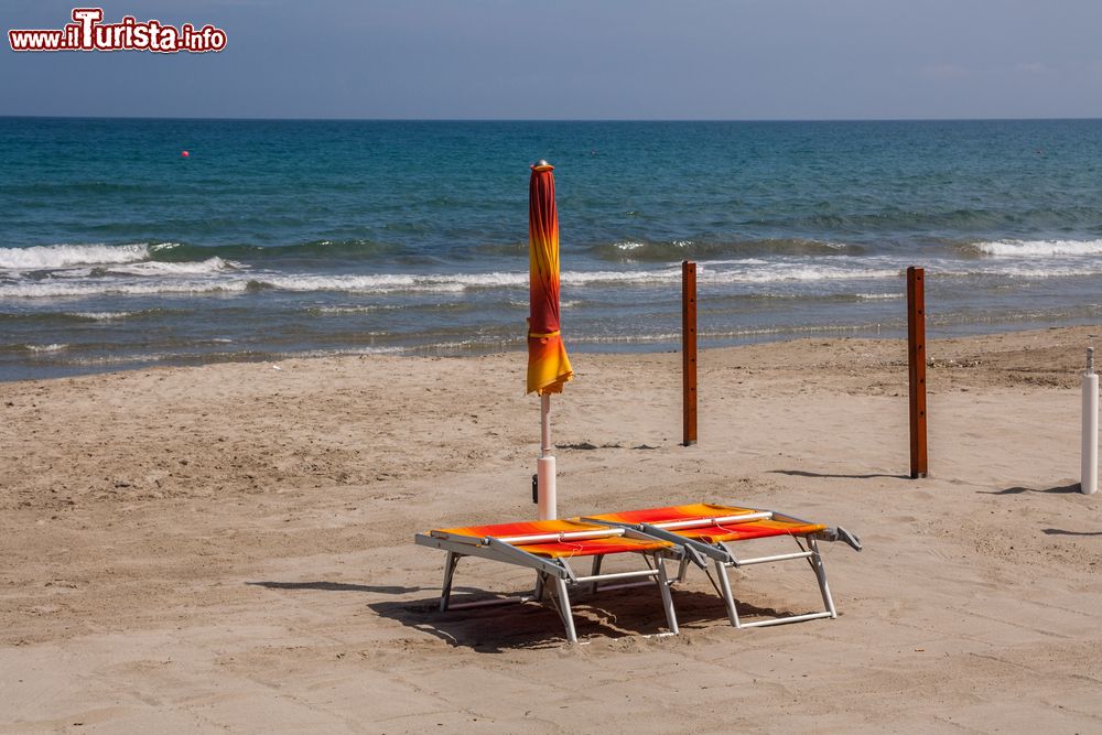 Immagine Ombrellone e sdraio sulla spiaggia deserta di Laigueglia, Liguria.