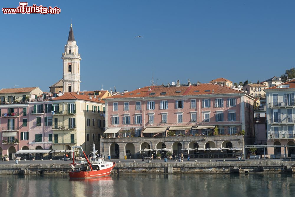 Immagine Oneglia (Imperia): un peschereccio attraccato al porto cittadino. Sullo sfondo, case e campanile.