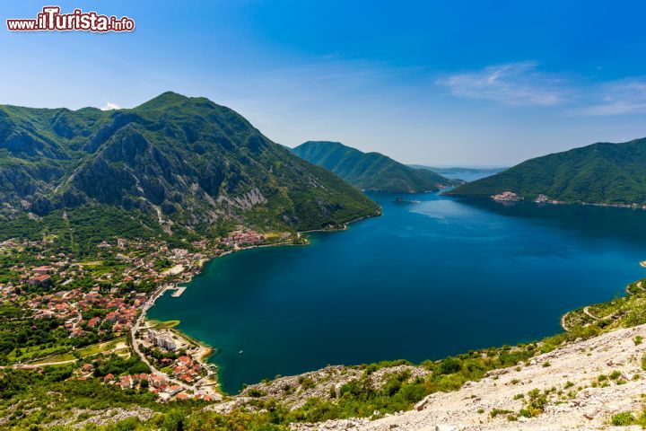 Immagine Paesaggio delle Bocche di Cattaro con la città di Risano, Montenegro. Situata in fondo al golfo, nella zona più interna e riparata delle Bocche di Cattaro, Risano sorge in una zona carsica e decisamente piovosa. Proprio la sua posizione geografica, protetta dalle pendici del monte Orjen e dallo stretto delle Catene, ne ha determinato nei secoli l'antica prosperità. In questa immagine scattata dall'alto, la città è circondata da montagne e si affaccia sulle acque cristalline del mare - © Mladen Davidovic / Shutterstock.com