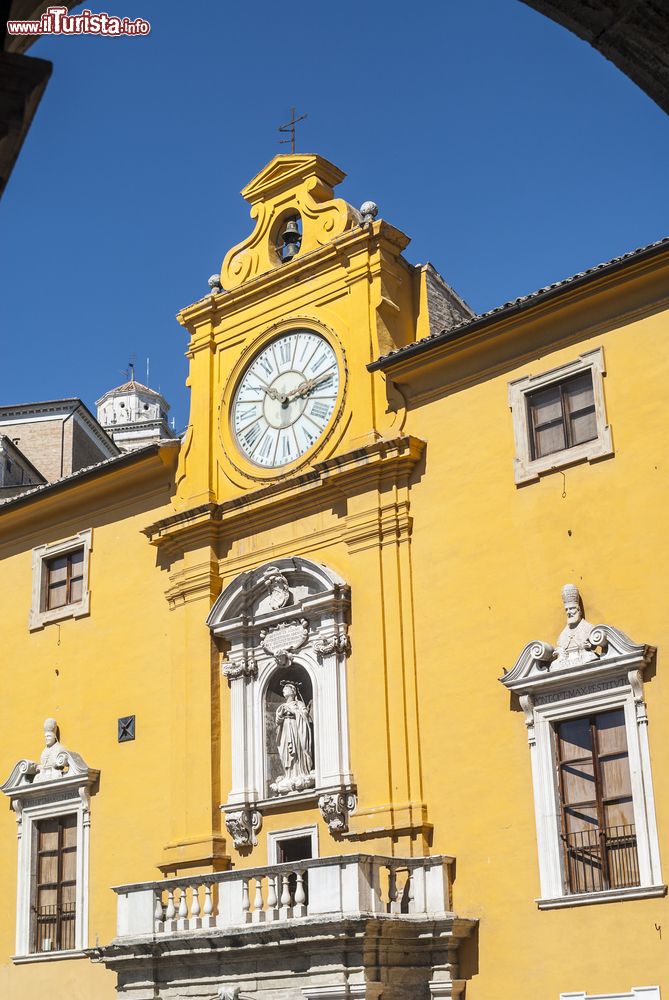 Immagine Palazzo storico con orologio, statua e balcone nel centro di Fermo (Marche).