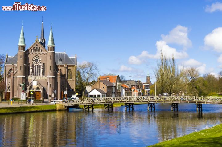 Immagine Il panorama delle case di Alkmaar e il canale, Olanda - Questi continui virtuosismi sviluppati in altezza in prossimità di specchi d'acqua, danno ad Alkmaar moltissimi scenari duplici dove gli edifici, che si riflettono nei canali, sembrano ancora più imponenti. In questa immagine, infatti, così ricca di riflessi, sembra di guardare il paesaggio dipinto da un artista, impeccabile in ogni suo dettaglio - © Tanya Ustenko / Shutterstock.com