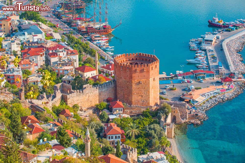 Immagine Panorama con la marina e la Kizil Kule nella penisola di Alanya, distretto di Antalya, Turchia. Si tratta di uno dei migliori esempi di architettura militare medievale ed è anche l'edificio meglio conservato della città. Come da tradizione, la torre è sormontata da una merlettatura.