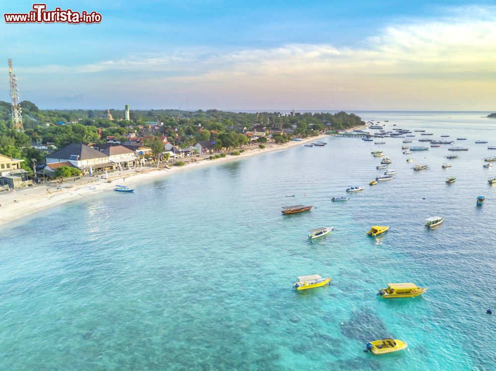 Immagine Panorama dall'alto dell'isola di Gili Trawangan all'alba, Indonesia, con decine di barche ormeggiate al largo della costa.