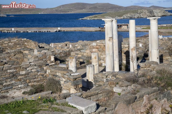 Immagine Panorama dall'alto sulla casa di Cleopatra a Delos, Grecia. Le colonne di marmo bianco si stagliano sullo sfondo blu azzurro del Mare Egeo che lambisce le coste di quest'isola un tempo nota con il nome di Ortigia