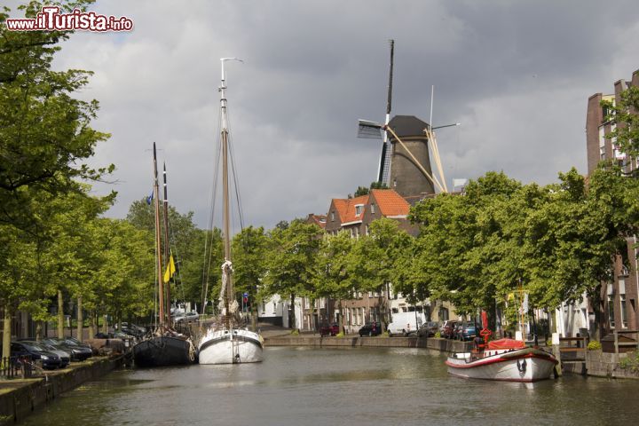 Immagine Panorama del canale con le barche e un mulino a vento a Schiedam, Olanda. In questa città dell'Olanda meridionale si trovano i più alti mulini a vento del mondo che raggiungono i 33 metri di altezza.