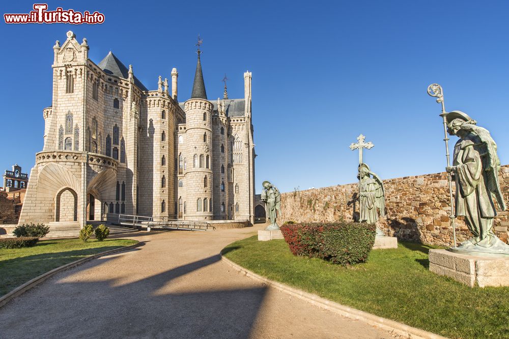 Immagine Panorama del Palazzo Episcopale di Astorga, Spagna, con i tre angeli di zinco nel giardino antistante. Gaudì li ideò per collocarli nei punti più alti del tetto ma arrivarono ad Astorga solo nel 1913 e vennero infine posizionati nel giardino.