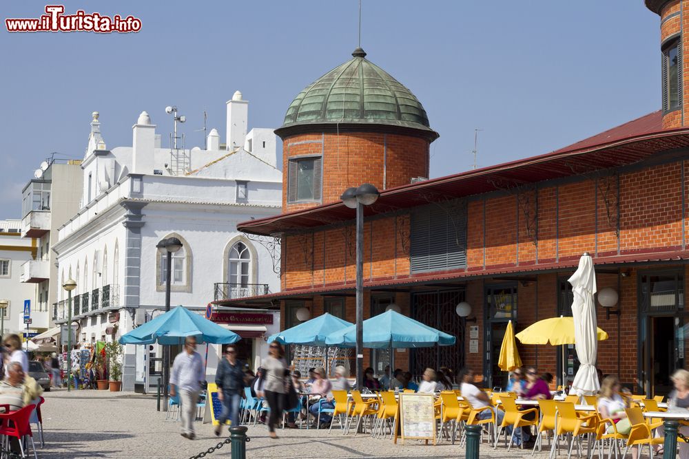 Immagine Panorama della tradizionale area mercatale di Olhao, Portogallo. Turisti passeggiano in questa zona della città per andare alla scoperta dei suoi angoli più caratteristici.