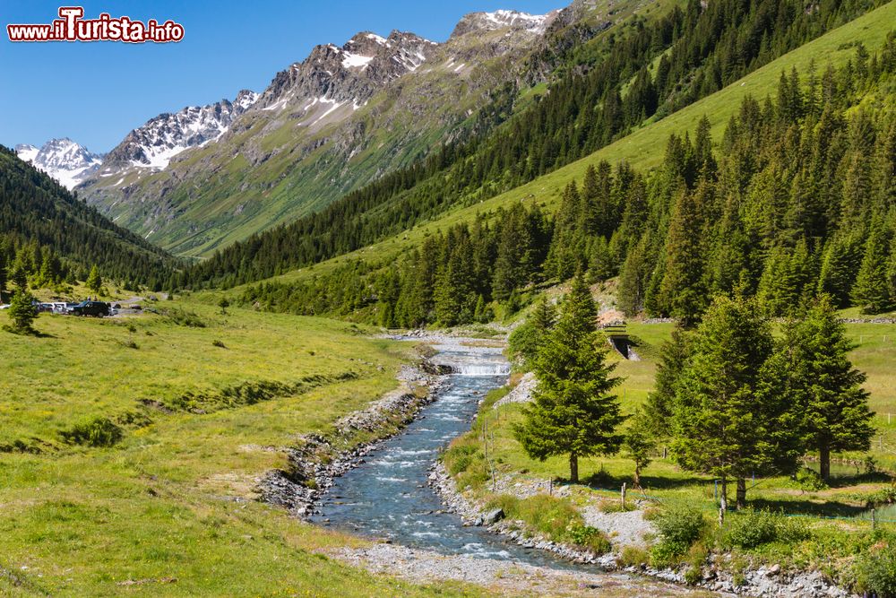 Immagine Panorama della valle Jamtal con prati verdi e un torrente di montagna: siamo nei pressi di Menta Alm, Galtur (Austria), in una giornata di sole.