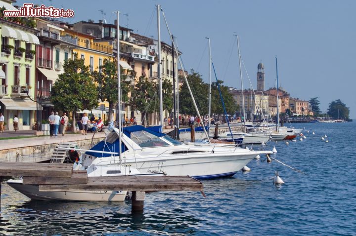 Immagine Panorama di Salò, Lombardia. Alcune fonti fanno risalire il nome della città a origini etrusche, in particolare al nome Salodia mentre altri lo collegano al termine latino salodium che indicava le sale e le stanze di cui erano ricche le ville sul lago in epoca romana. Un'altra spiegazione farebbe risalire il nome di Salò all'abbondante presenza di sale marino: già durante i tempi antichi, questa cittadina era infatti collegata all'Adriatico attraverso il Mincio e il Po - © Khirman Vladimir / Shutterstock.com