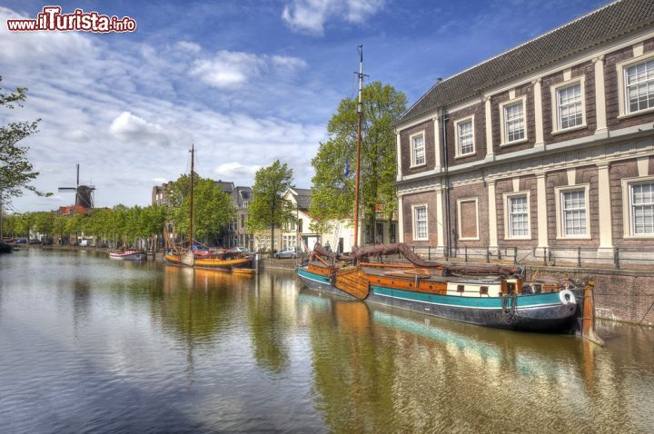 Immagine Panorama di Schiedam con vecchie imbarcazioni, abitazioni e un mulino a vento in lontananza, Olanda.