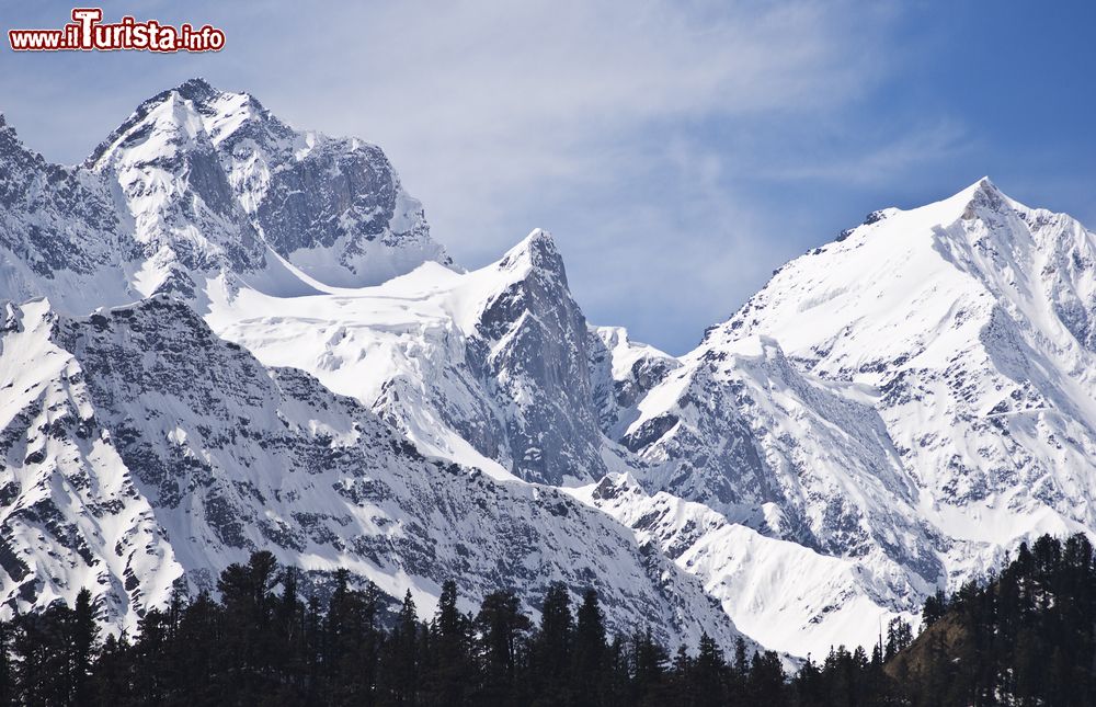 Immagine Panorama innevato dell'Himalaya sopra Kullu Valley, stato dell'Himachal Pradesh, India. La vallata Kullu è celebre per  i suoi templi e per le maestose colline ricoperte di pini; il fiume Beas disegna un suggestivo corso fra canyon rocciosi.