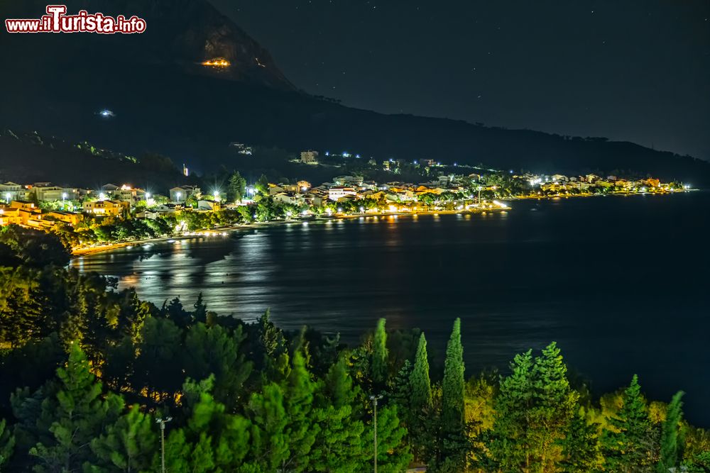 Immagine Panorama notturno di Tucepi, Crozia. Situata nel cuore della riviera di Makarska, questa graziosa località di mare è protetta dalle pendici del monte Biokovo.