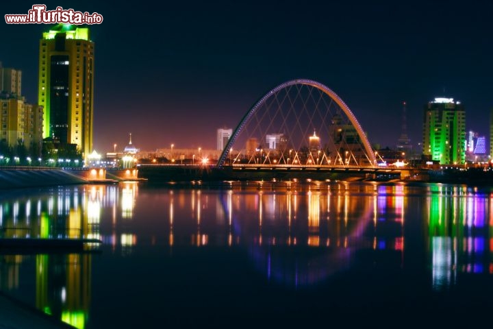 Immagine Panorama notturno sul fiume Ishim, Astana - Si rispecchiano nelle acque del fiume su cui sorge la capitale Astana le luci di edifici e ponti che creano una suggestiva atmosfera notturna alla skyline della città kazaka © filinphoto / Shutterstock.com