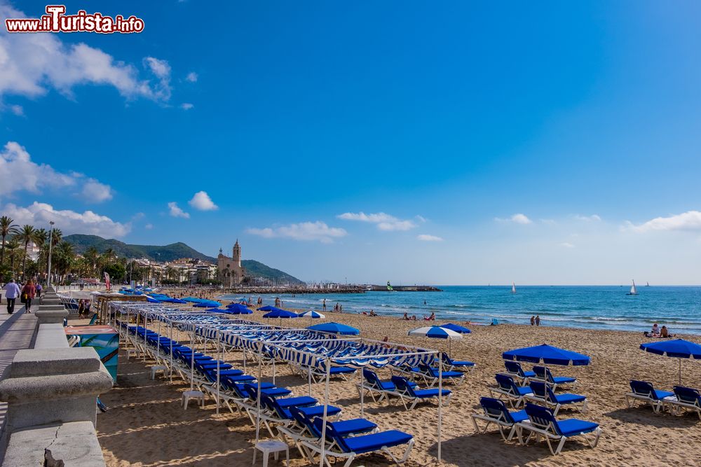 Immagine Panorama sulla spiaggia di Sitges, Spagna. Quasi tutte le spiagge della cittadina sono attrezzate con sdraio e ombrelloni.
