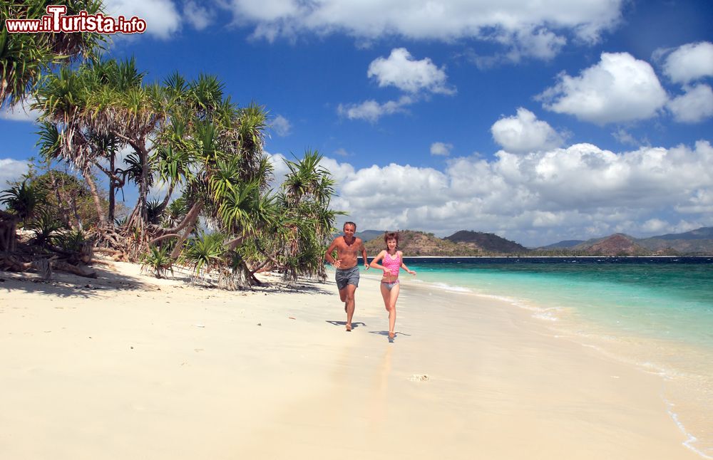 Immagine Papà e figlia corrono su una spiaggia delle isole Gili, Lombok, Indonesia.