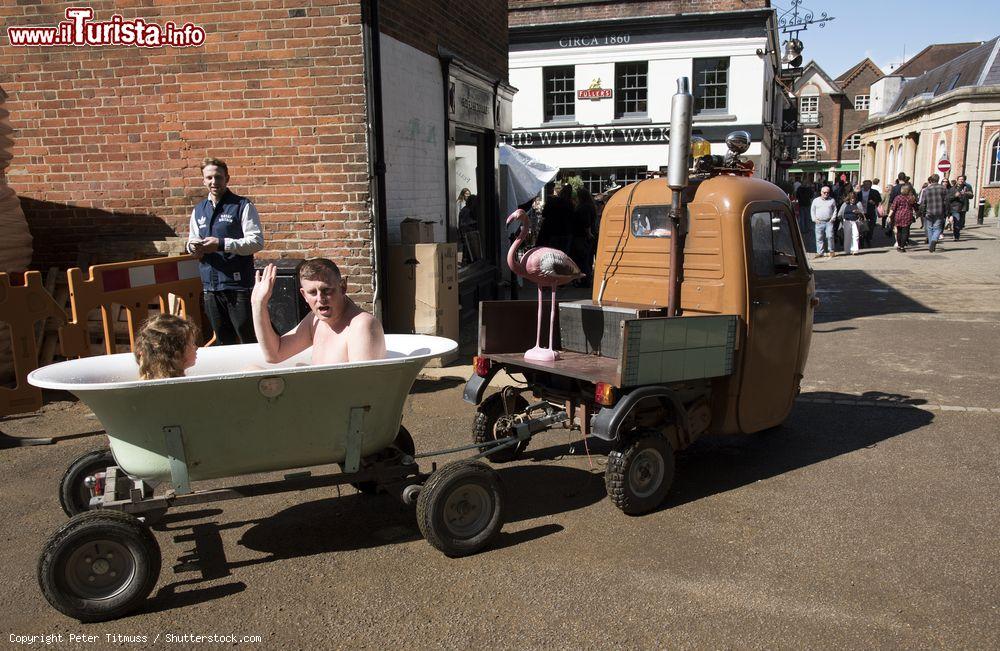 Immagine Partecipanti all'annuale Hat Fair impegnati in un giro della città in un bagno mobile a Winchester, Inghilterra. Indossano costumi e sono immersi nell'acqua calda - © Peter Titmuss / Shutterstock.com