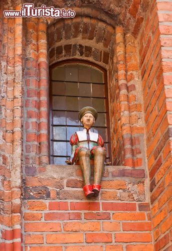 Immagine Particolare del Municipio della Città Vecchia di Torun, Polonia. Una bella decorazione in ceramica di un personaggio medievale, opera dello scultore Dariusz Przewiezlikowski, collocata nella nicchia di una finestra. Situata al centro della Piazza del Mercato della Città Vecchia, questa costruzione è uno degli esempi più importanti di architettura medievale europea: la torre è la più antica dell'Europa centro-orientale - © Joymsk / Shutterstock.com