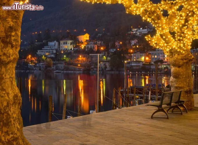 Immagine Particolare della passeggiata lungolago a Ascona, Svizzera. Le luci delle abitazioni e delle decorazioni luminose si riflettono sulle acque del Lago Maggiore - © RnDmS / Shutterstock.com