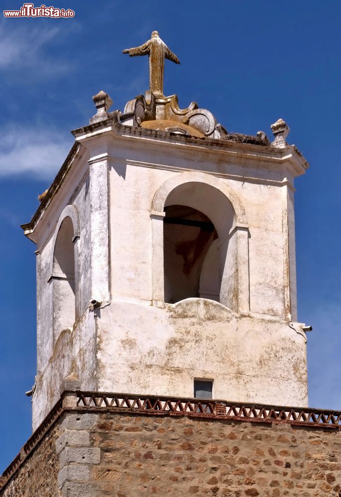 Immagine Particolare di un campanile nella città di Jerez de los Caballeros, Spagna. Sulla sommità si trova una statua di Gesù Cristo con le braccia aperte.