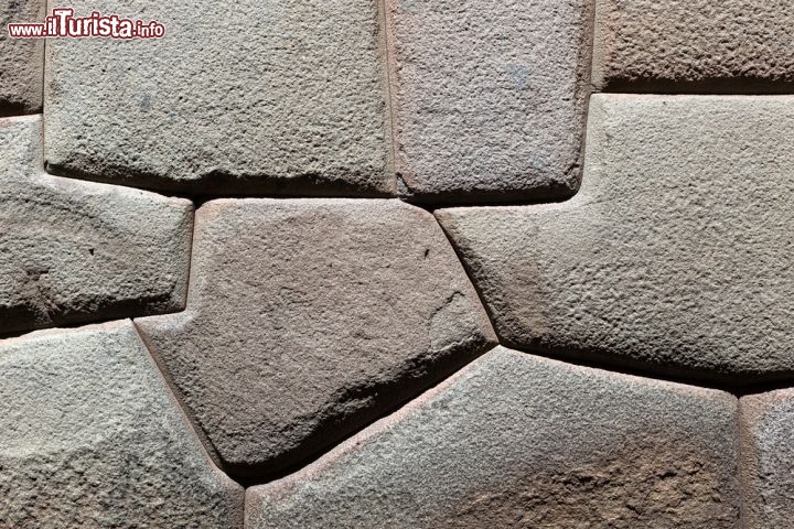 Immagine Particolare di un muro inca a Machu Picchu, Perù - A chiederselo sono anche studiosi e archeologi che hanno indicato nelle tecniche costruttive di questo anticolo popolo una fra le più sofisticate in assoluto. Per comprendere la bravura dei costruttori inca è sufficiente osservare il taglio e l'alloggiamento delle pietre in granito perfettamente incastrate l'una all'altra tanto da rendere impossibile anche il passaggio di una sottile lama di coltello nelle fessure - © sunsinger / Shutterstock.com