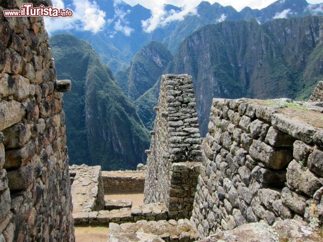 Immagine Passeggiata fra le rovine di Machu Picchu, Perù - La posizione della città per secoli fu un segreto militare ben custodito in quanto i profondi dirupi che la circondano ne erano anche la migliore difesa naturale. Una volta abbandonata infatti rimase nascosta agli occhi del mondo per quasi 400 anni entrando così nella leggenda. Secondo le scoperte archeologiche e i documenti riportati alla luce pare che fosse la residenza estiva dell'imperatore e della nobiltà inca: solo 750 persone alla volta erano autorizzate a risiedervi e quando non c'erano nobili o in tempo di pioggia il numero scendeva ancora maggiormente - © ckchiu / Shutterstock.com