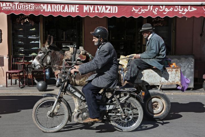 Immagine Antico e moderno a Marrakech, Marocco - Una simpatica immagine scattata nel centro di Marrakech che ritrae il contrasto fra passato e presente: qui ci si sposta in moto ma anche su carretti trainati da asini