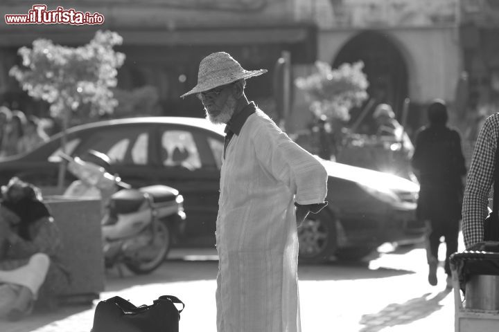 Immagine Un uomo a passeggio nella piazza Jamaa el Fna a Marrakech, Marocco - E' il centro vitale della città oltre che il simbolo stesso per eccellenza: in piazza Jamaa el Fna, che confina a nord con il quartiere dei suq e a est con la Qasba, si ritrovano non solo i turisti provenienti da tutto il mondo ma anche gli abitanti di Marrakech