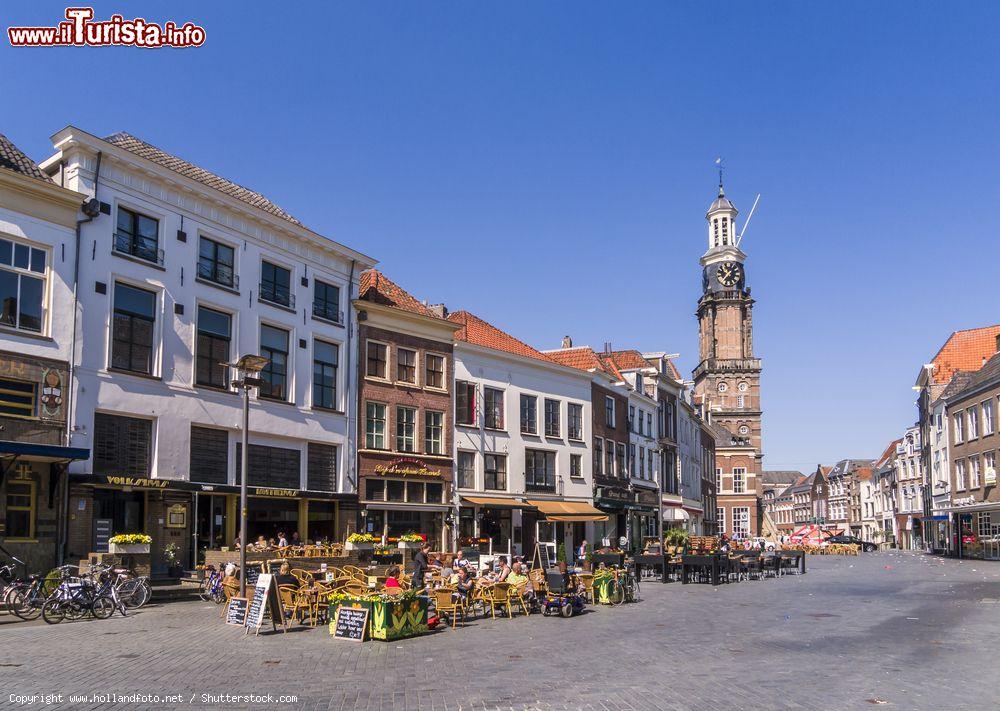 Immagine Persone intente a bere un drink in piazza Houtmarkt a Zutphen, Olanda. La giornata soleggiata e la 'Wijnhuistoren' sono la perfetta cornice per una sosta in uno dei locali cittadini - © www.hollandfoto.net / Shutterstock.com