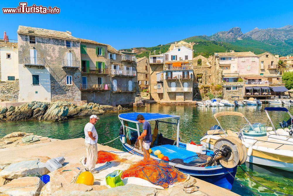 Immagine Pescatori puliscono le reti nel porticciolo di Erbalunga, Corsica, Francia. Questo piccolo villaggio dedito alla pesca si trova a Capo Corso, penisola situata nel nord est della Corsica - © Pawel Kazmierczak / Shutterstock.com