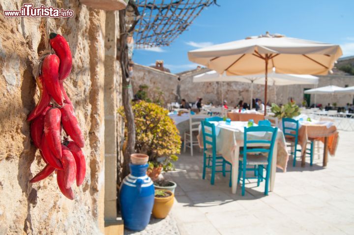 Immagine Piazza centrale di Marzamemi, Sicilia - I colori caldi della Sicilia rispecchiano l'atmosfera di una terra profondamente legata alla pesca. La bellezza di piazza Regina Margherita lascia senza parole: qui si affacciano le due chiese del borgo, entrambe dedicate al santo patrono Francesco da Paola, il palazzo di Villadorata e tutt'attorno le case dei pescatori © Marco Ossino / Shutterstock.com