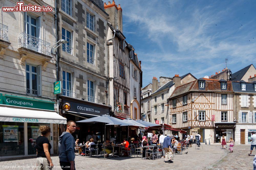 Immagine Piazza nei pressi di Notre Dame la Grande a Poitiers, Francia, con gente seduta nei locali all'aperto - © Miroslaw Skorka / Shutterstock.com