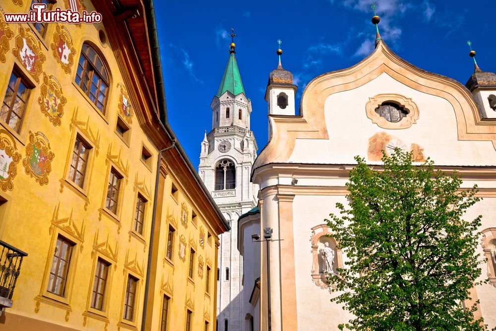 Immagine La piazza principale di Cortina d' Ampezzo, Veneto, con edifici religiosi e un edificio storico.