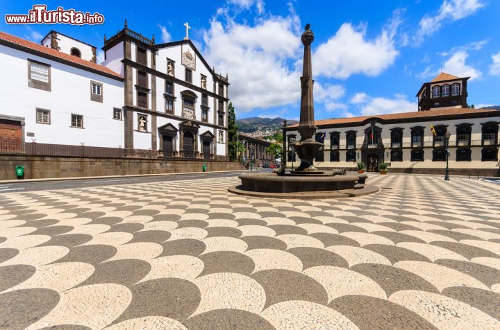 Immagine La piazza principale di Funchal a Madeira (Portogallo) - Ogni città riflette nel suo pavimento qualcosa di molto prezioso riguardante la sua identità. A Roma ci sono i famosi ciottoli, a Genova i marmi, a Ravenna i mosaici, a Funchal invece vi sono le vele. I motivi geometrici, infatti, ricordano il simbolo della Santa Maria, la nave di Colombo, ammirabile dalla costa. Il loro impiego che abbraccia la vista di tutta la piazza, regala un mare senza blu, in perfetta armonia cromatica con l'edilizia fatta di colori bianchi. Il monumento centrale molto sviluppato in altezza poi, spezza la visione proprio come se fosse un faro, scelta che rende il tutto piuttosto affascinante - © Pawel Kazmierczak / Shutterstock.com