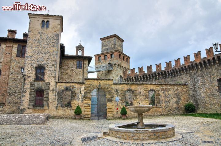 Immagine Il piazzale con fontana del Castello di Vigoleno. La struttura vanta probabilmente circa 1000 anni di soria, anche se i primi documenti lo citano nel 12° secolo - © Mi.Ti. / Shutterstock.com