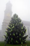 Il campanile della cattedrale di San Gallo avvolto nella nebbia e uno dei tanti alberi di Natale sparsi per la città