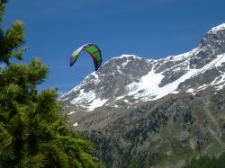 Vela di un kitesurf si staglia nel cielo di Silvaplana