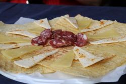 Aperitivo gallurese ad Aggius: Pane Carasau, abbondante formaggio pecorino sardo e gustose fette di salame, il tutto accompagnato da abbondante vermentino di gallura