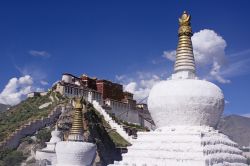 Architetture tibetane in primo piano, mentre  in lontananza si vede il profilo inconfondibile del Potala Palace di Lhasa, l'edificio più celebre del Tibet, la regione della Cina ...