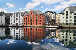 Alesund, regione del Sunnmøre, lungo la costa occidentale della Norvegia: le case colorate della città si specchiano nella baia in tutto il loro allegro splendore. L'acqua ...