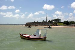 Barca in spiaggia a Joao Pessoa, la capitale del Paraiba Brasile. Sullo sfondo il Tropical Tambau Hotel, dalla originale forma rotonda - © casadaphoto / Shutterstock.com
