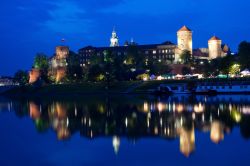 Castello di Wawel a Cracovia, di notte si riflette sulle acque del fiume Wisla della Polonia - © Iurii Konoval / Shutterstock.com