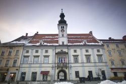 Neve nel centro storico di Maribor, Slovenia - Su Glavni trg, la principale piazza di Maribor, si affaccia il Palazzo Comunale della città con la sua caratteristica torre dell'orologio. ...