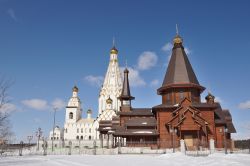 Minsk, capitale della Bielorussia: una tipica chiesa ortodossa in pietra e in legno e la Chiesa di Tutti i Santi in una giornata di sole - © YuryZap / Shutterstock.com