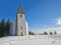 Paesaggio innevato sulla chiesa di Areh, Maribor - A 1249 metri sul livello del mare, nel cuore delle foreste verdi di Pohorje sorge la chiesetta di Areh, uno dei patrimoni storici e religiosi ...