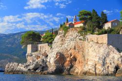 Chiesa cittadina e rocce a picco sul mare a Sveti Stefan, Montenegro - © Carmen Avram / Shutterstock.com