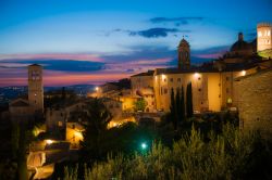 Crepuscolo sul borgo di Assisi: con le sfumature rossastre del cielo che si riflettono sulle facciate delle abitazioni e su strade e piazze, il fascino emanato dalla città umbra, che ...