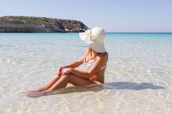 Donna in relax sulla spiaggia dei Conigli a Lampedusa (Italia) - © RZ Design / Shutterstock.com