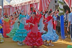 Il flamenco a Siviglia durante la Feria de Abril: è tutto un volteggiare di tessuti colorati e vaporosi, chiome scure e braccia aggraziate - © SandiMako / Shutterstock.com